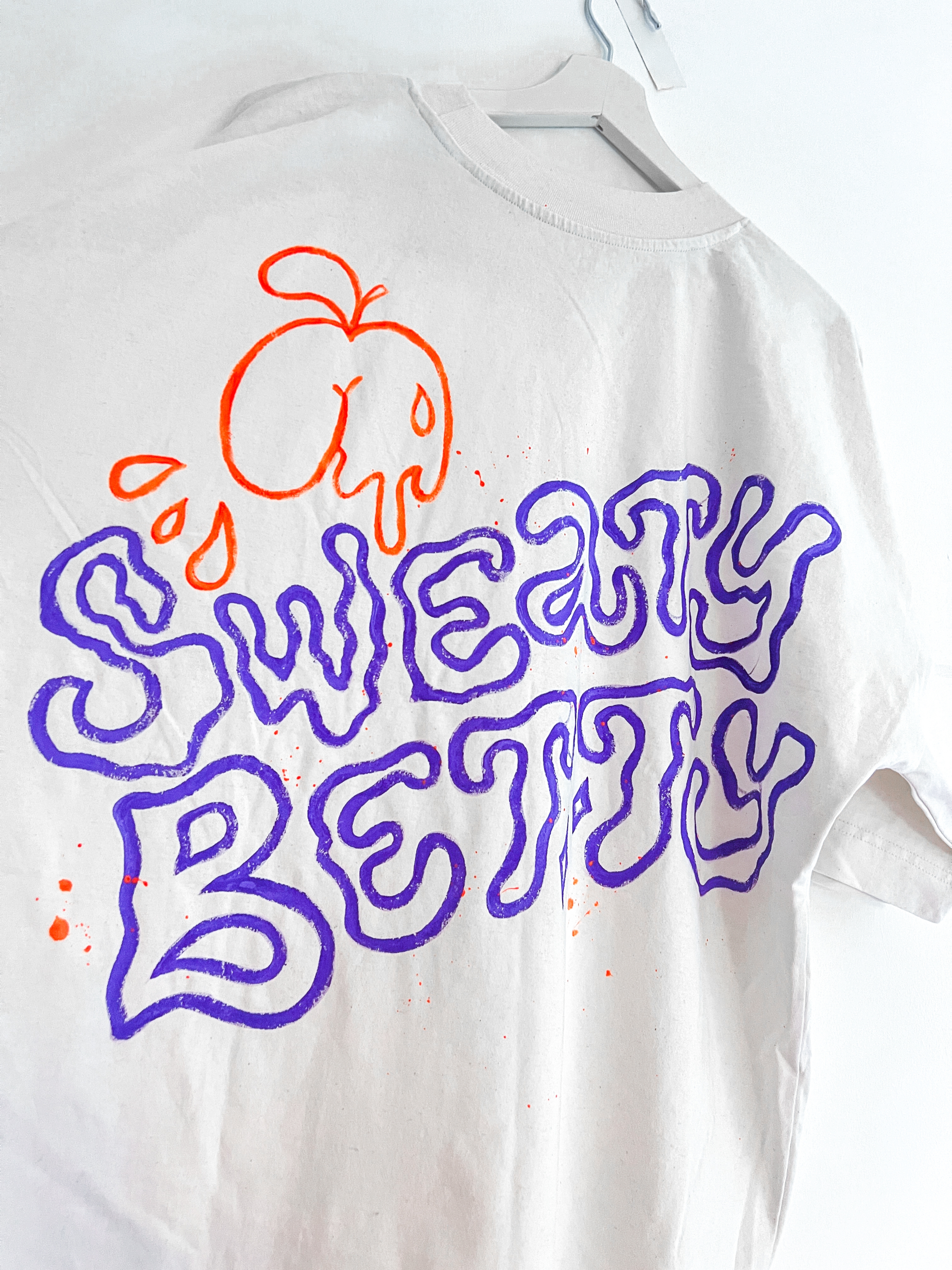 Sweaty Betty hand-painted lettering on a t-shirt