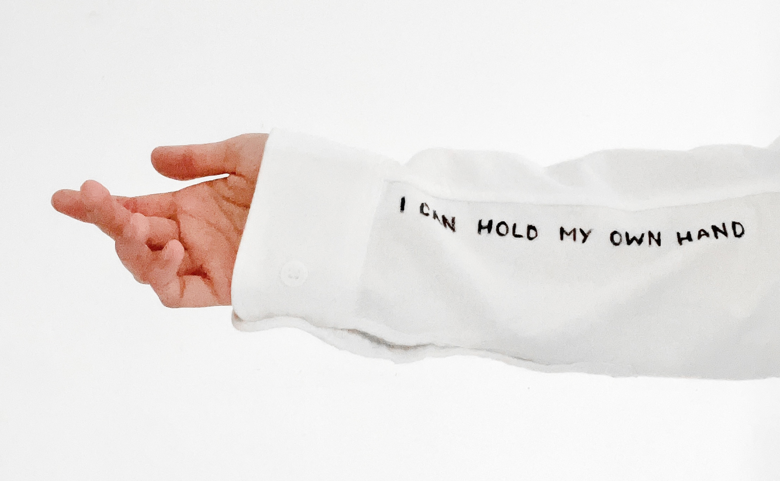 A sign on the sleeve of the shirt saying "I can hold my own hand"